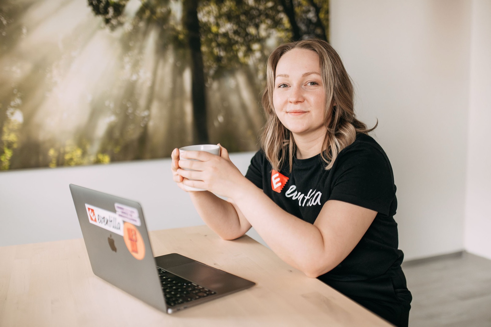 A CompetenceFlow team member with a coffee at her laptop in the Oulu office in Finland