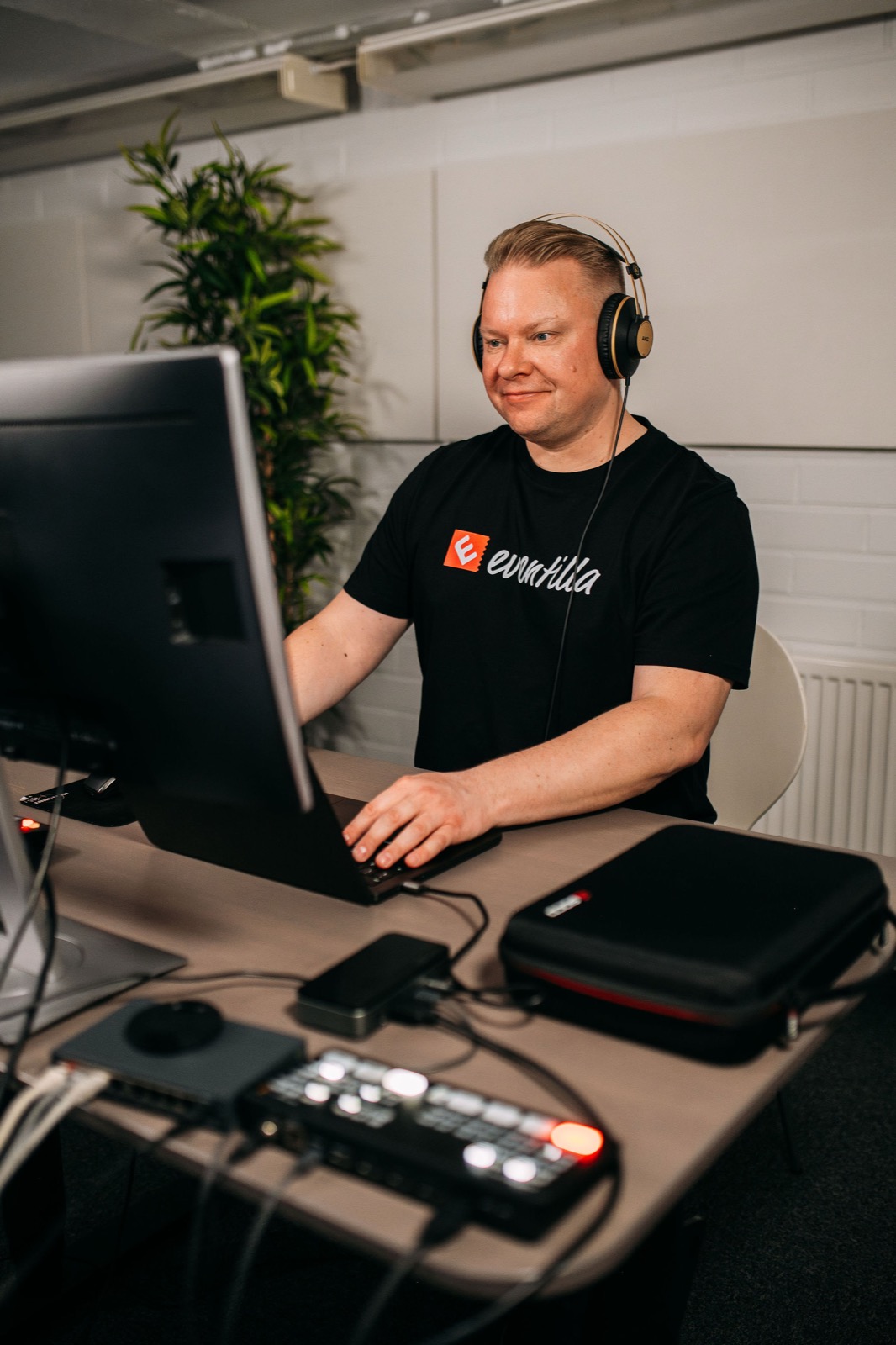 A CompetenceFlow team member working with headphones at a desk in the Oulu office in Finland