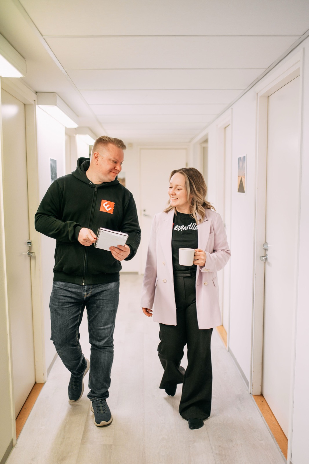 Two members of the CompetenceFlow team walking and talking through the office in Oulu, Finland